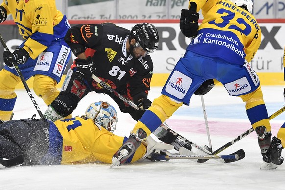 Berns Thomas Ruefenacht, Mitte, im Duell gegen Davos&#039; Goalie Gilles Senn, links, und Noah Schneeberger im Eishockey National League A Spiel zwischen dem SC Bern und dem HC Davos, am Freitag, 25.  ...