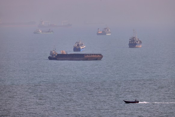 A small boat sails past cargo ships and other commercial vessels anchored in the Strait of Hormuz off Bandar Abbas, Iran, Wednesday, Aug. 5, 2026. (Amirhosein Khorgooi/ISNA via AP)
Iran War Strait of  ...