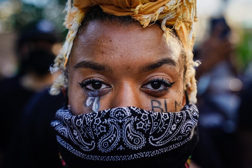ATLANTA, GA - MAY 31: A woman with 'BLM' written on her cheek poses for a picture during a demonstration on May 31, 2020 in Atlanta, Georgia. Across the country, protests have erupted follow ...