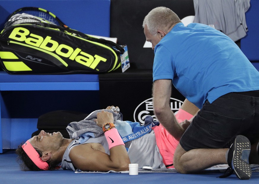 Spain&#039;s Rafael Nadal receives treatment from a trainer during his quarterfinal against Croatia&#039;s Marin Cilic at the Australian Open tennis championships in Melbourne, Australia, Tuesday, Jan ...