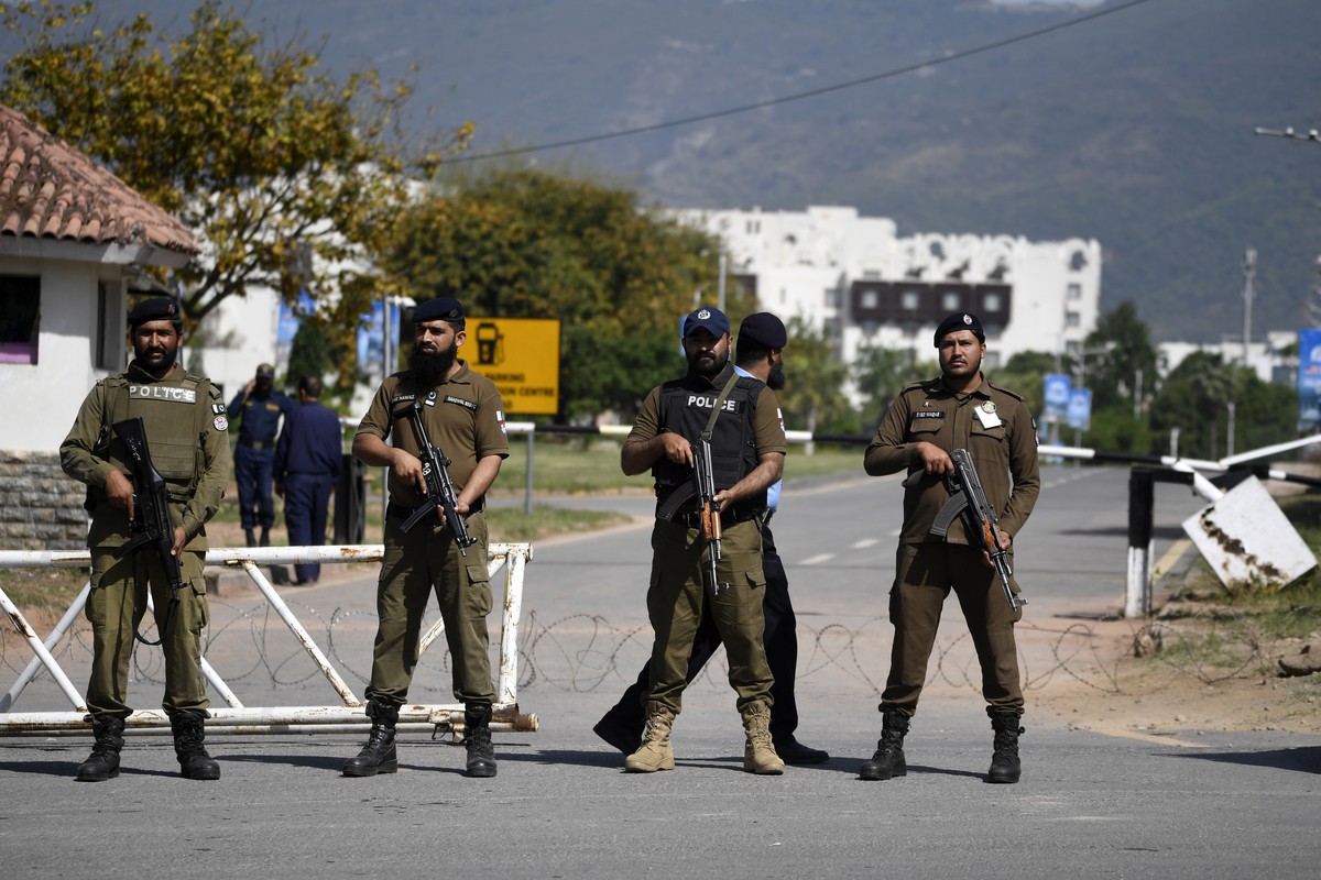 epa12901684 Pakistani security officials stand guard on a road leading to the red zone where most of the diplomatic missions and government offices are situated, including the venue of the expected se ...