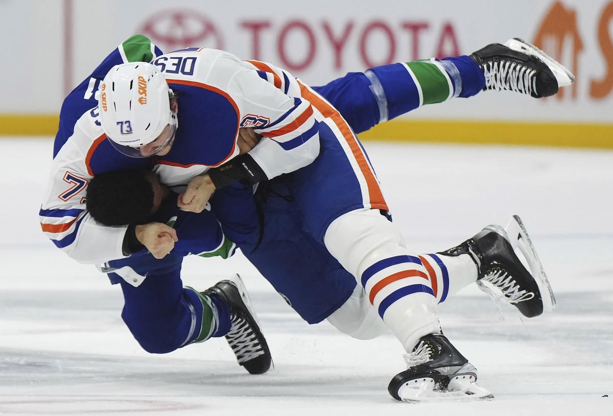 Vancouver Canucks' Dakota Joshua, bottom, and Edmonton Oilers' Vincent Desharnais fight during the first period of an NHL hockey game Wednesday, Oct. 11, 2023, in Vancouver, British Columbia ...