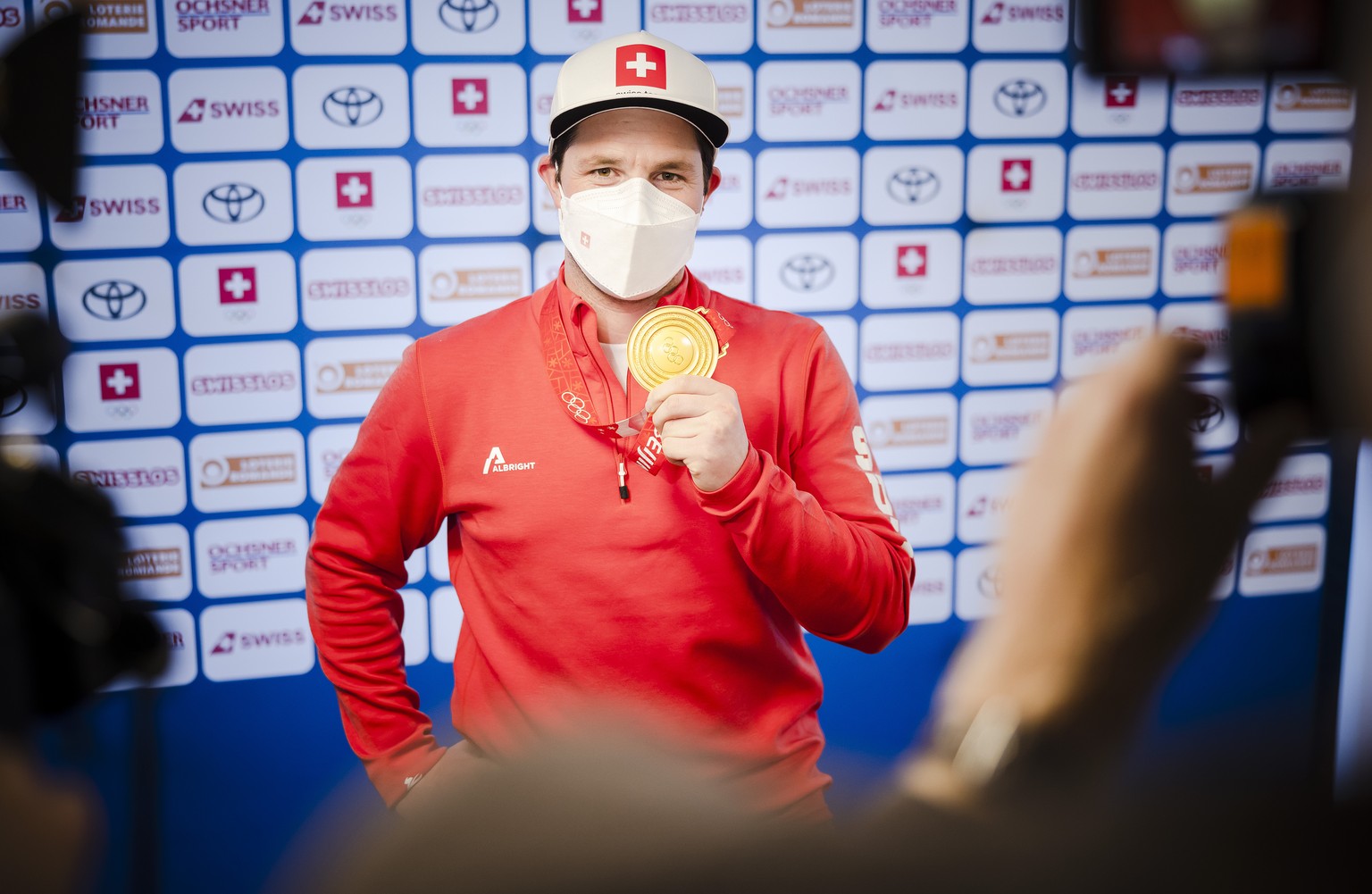 Olympia Goldmedaillengewinner Beat Feuz zeigt bei seiner Ankunft am Flughafen Zuerich seine Goldmedaille den Medien, am Mittwoch, 9. Februar 2022 in Zuerich Kloten. (KEYSTONE/Michael Buholzer)