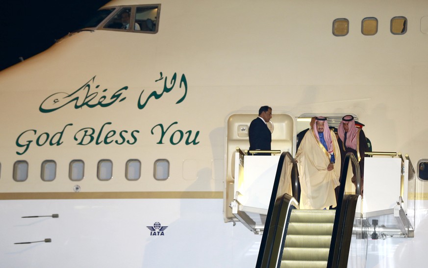 Saudi King Salman, center, rides on a special escalator to disembark from his plane upon his arrival at Haneda International Airport in Tokyo, Sunday, March 12, 2017. Salman arrived in Japan as part o ...