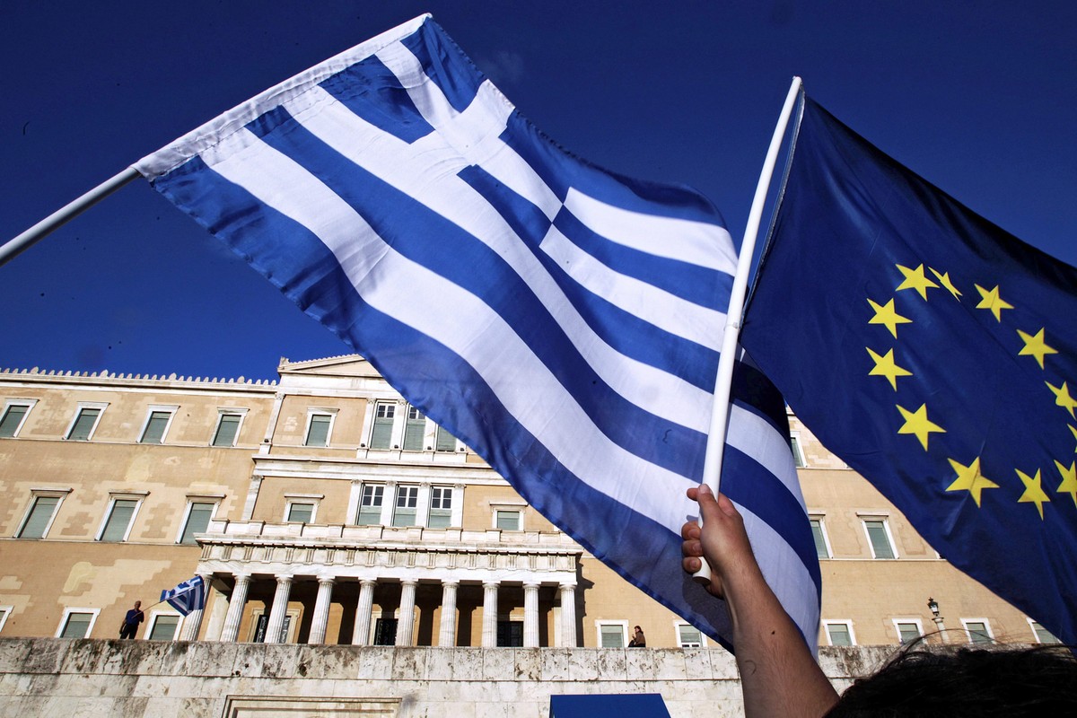 epa04814689 Protesters hold a Greek and a EU flag outside the parliament during a rally demanding Greece to remain in the Eurozone in Athens, Greece, 22 June 2015. The Eurozone's 19 national lead ...