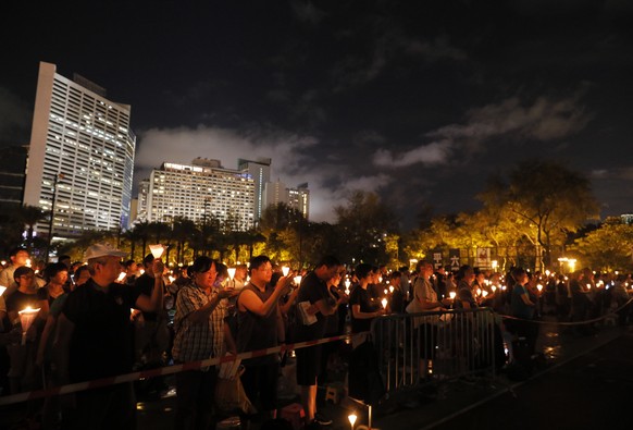 Protesters raise a Chinese Communist Party flag with Chinese words that read: &quot;Put an end to one-party Dictatorship&quot; as hundreds of Hong Kong people march on a downtown street in Hong Kong,  ...