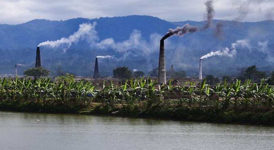 epa06382696 Bricklin factories furnace towers emit clouds of smoke in Morigaon district of Assam state, India, 11 December 2017. Bricks are in high demand for construction work in Guwahati city. As th ...