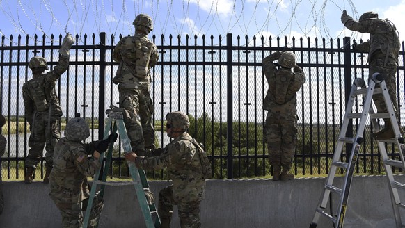 epa07145956 A handout photo made available by the US Air Force shows US soldiers from various Engineering Units installing concertina wire on the Anzalduas International Bridge over the Rio Grande at  ...