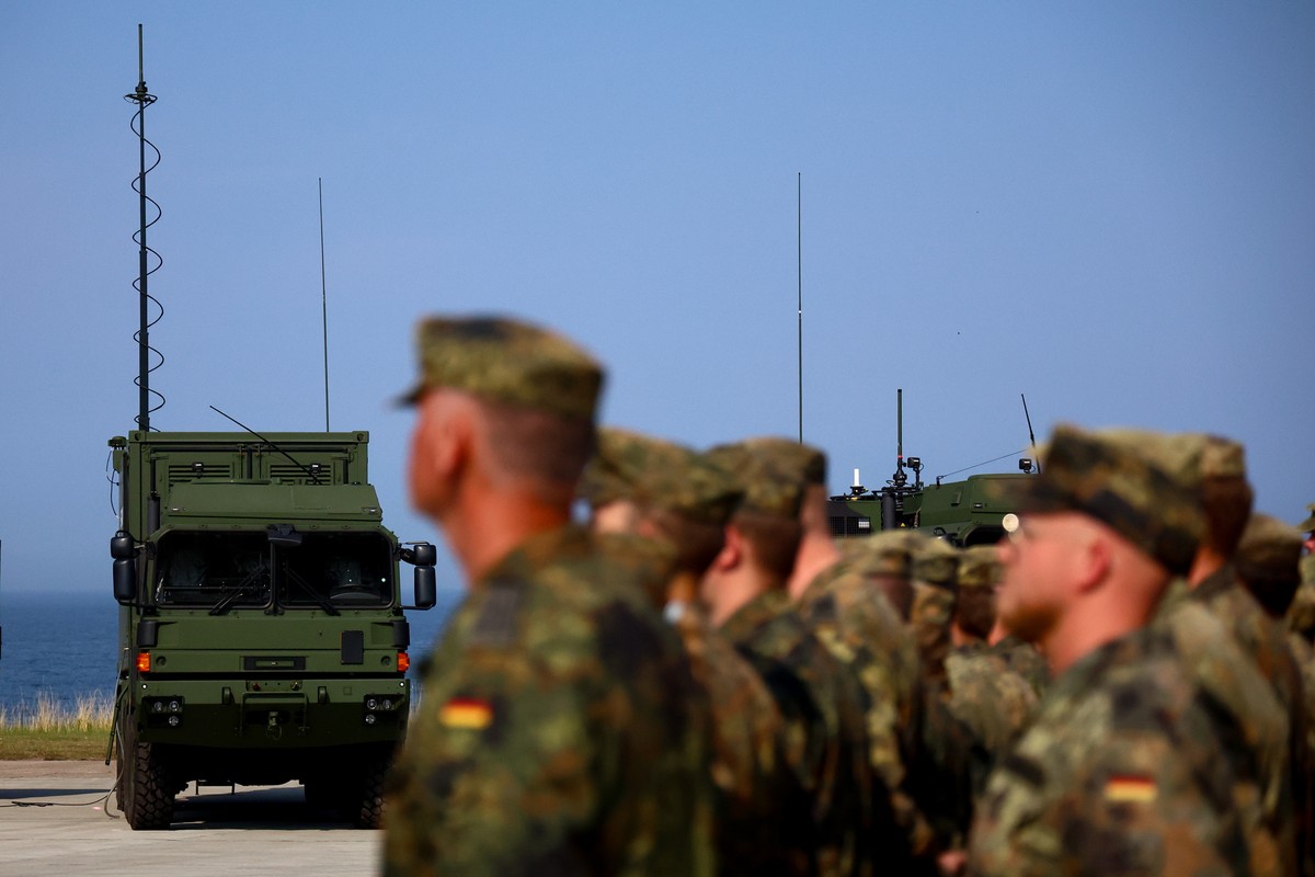 epa11584519 Soldiers stand next to vehicles of the IRIS-T SLM air defense system from Diehl Defence stationed on the grounds, during the ceremonial commissioning at the Todendorf barracks in Todendorf ...