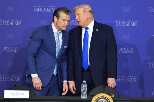 President Donald Trump talks with Defense Secretary Pete Hegseth, as he participates in a roundtable discussion on public safety at a Tennessee Air National Guard Base, Monday, March 23, 2026, in Memp ...