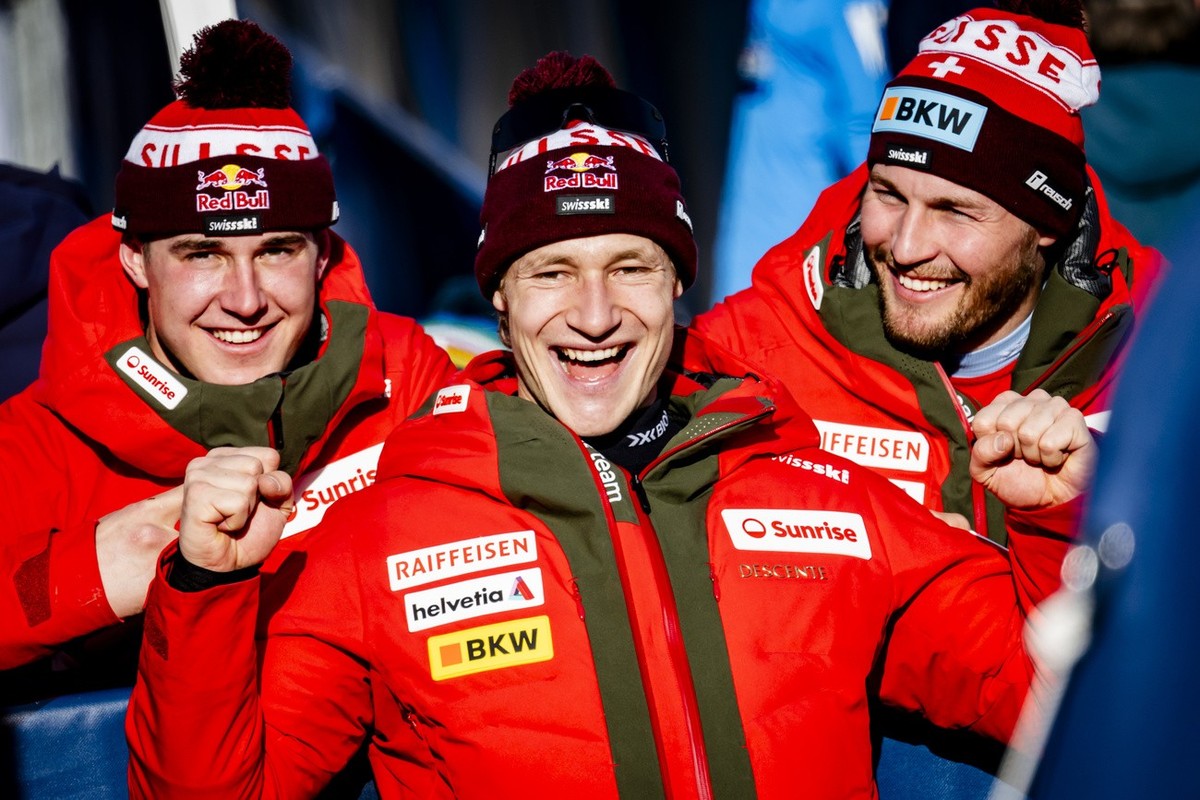 Franjo von Allmen, left, Marco Odermatt, center, and Alexis Monney, right, of Switzerland react in the finish area during the men's Super G race at the 2025 FIS Alpine World Ski Championships, in ...
