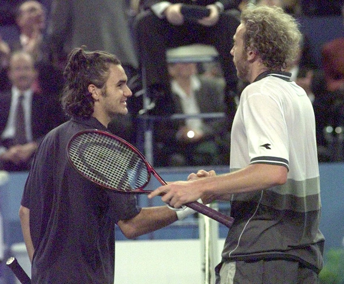 Switzerland's tennis player Roger Federer, left, shakes hand with his compatriot Marc Rosset, Sunday, February 13, 2000, in Marseille, southern France, after being defeated during the final of th ...