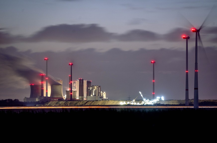 Steam rises from the coal-fired power plant at Neurath wind turbines near Grevenbroich, Germany, Wednesday, Nov. 2, 2022. (AP Photo/Michael Probst)