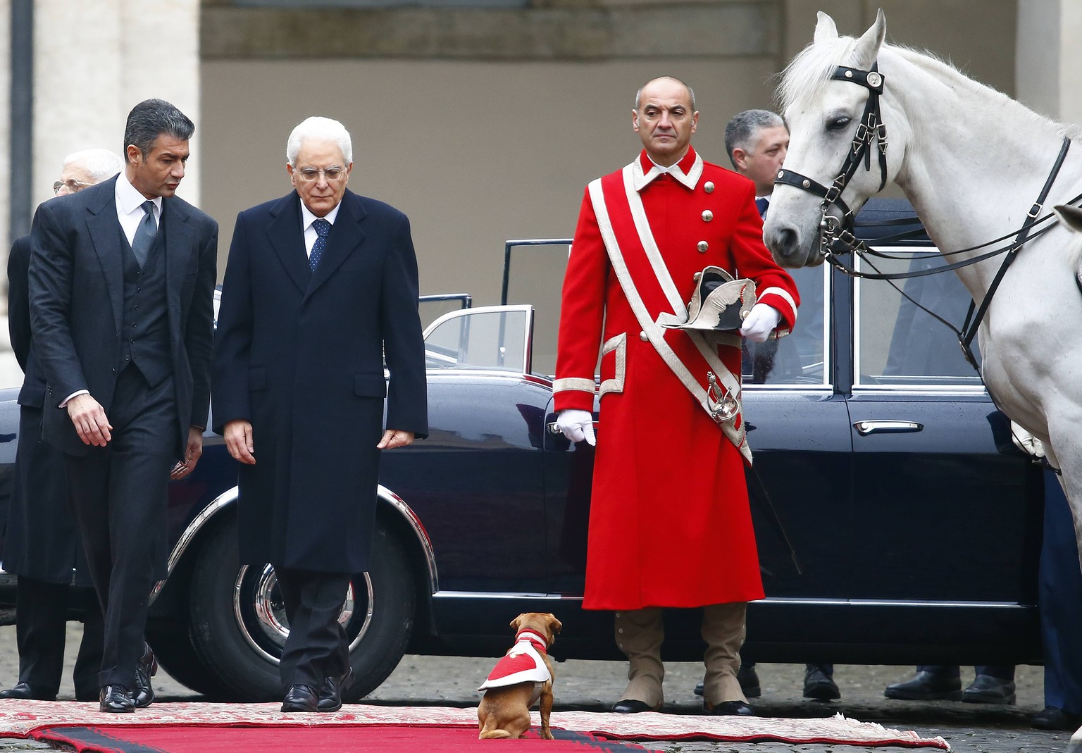 Sergio Mattarella (mitte) schreitet über den roten Teppich. Ein bisschen irritiert ihn das Hündchen schon.