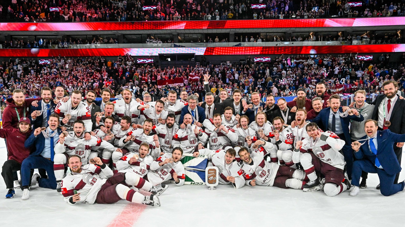 epa10660342 Players from team Latvia celebrate winning the bronze medal game between Latvia and the USA at the IIHF Ice Hockey World Championship 2023 in Tampere, Finland, 28 May 2023. EPA/KIMMO BRAND ...