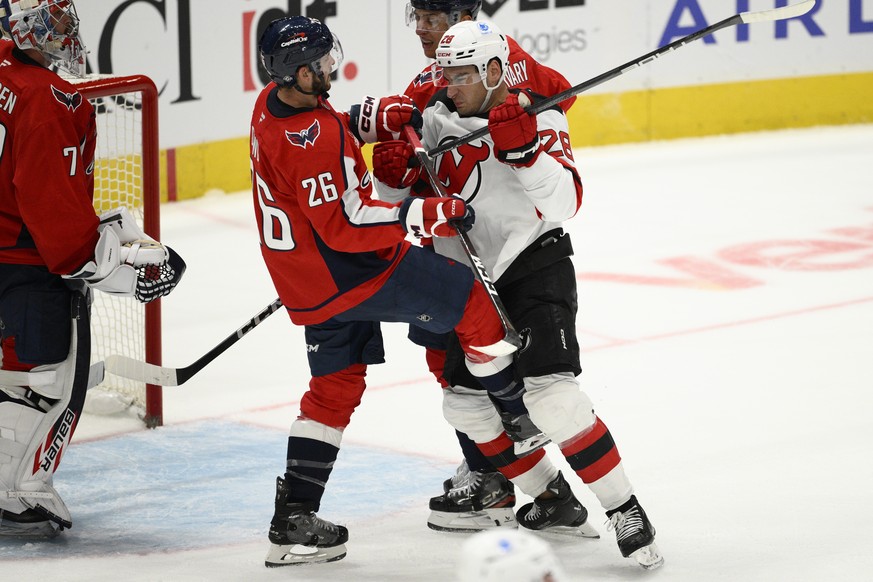 Washington Capitals center Nic Dowd (26) and New Jersey Devils right wing Timo Meier (28) scuffle during the third period of an NHL hockey game, Saturday, Oct. 12, 2024, in Washington. The Devils won  ...