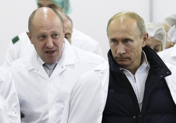 FILE - In this Monday, Sept. 20, 2010 file photo, businessman Yevgeny Prigozhin, left, shows Russian President Vladimir Putin, around his factory which produces school meals, outside St. Petersburg, R ...