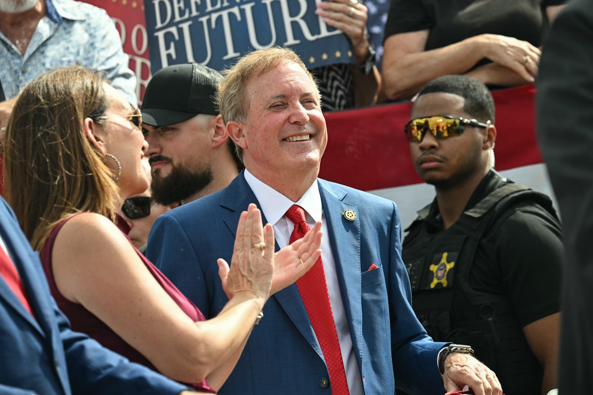 Texas Attorney General and Republican Senate candidate Ken Paxton smiles as Vice President JD Vance speaks during a campaign rally at Tyler Pounds Regional Airport in Tyler, Texas, Tuesday, Oct. 13, 2 ...