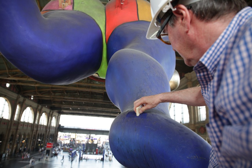 Konservator Christian Marty arbeitet am Schutzengel der Kuenstlerin Niki de Saint Phalle in der Haupthalle des Zuercher Hauptbahnhofs, am Freitag, 3. August 2018, in Zuerich. Seit mehr als 20 Jahren w ...