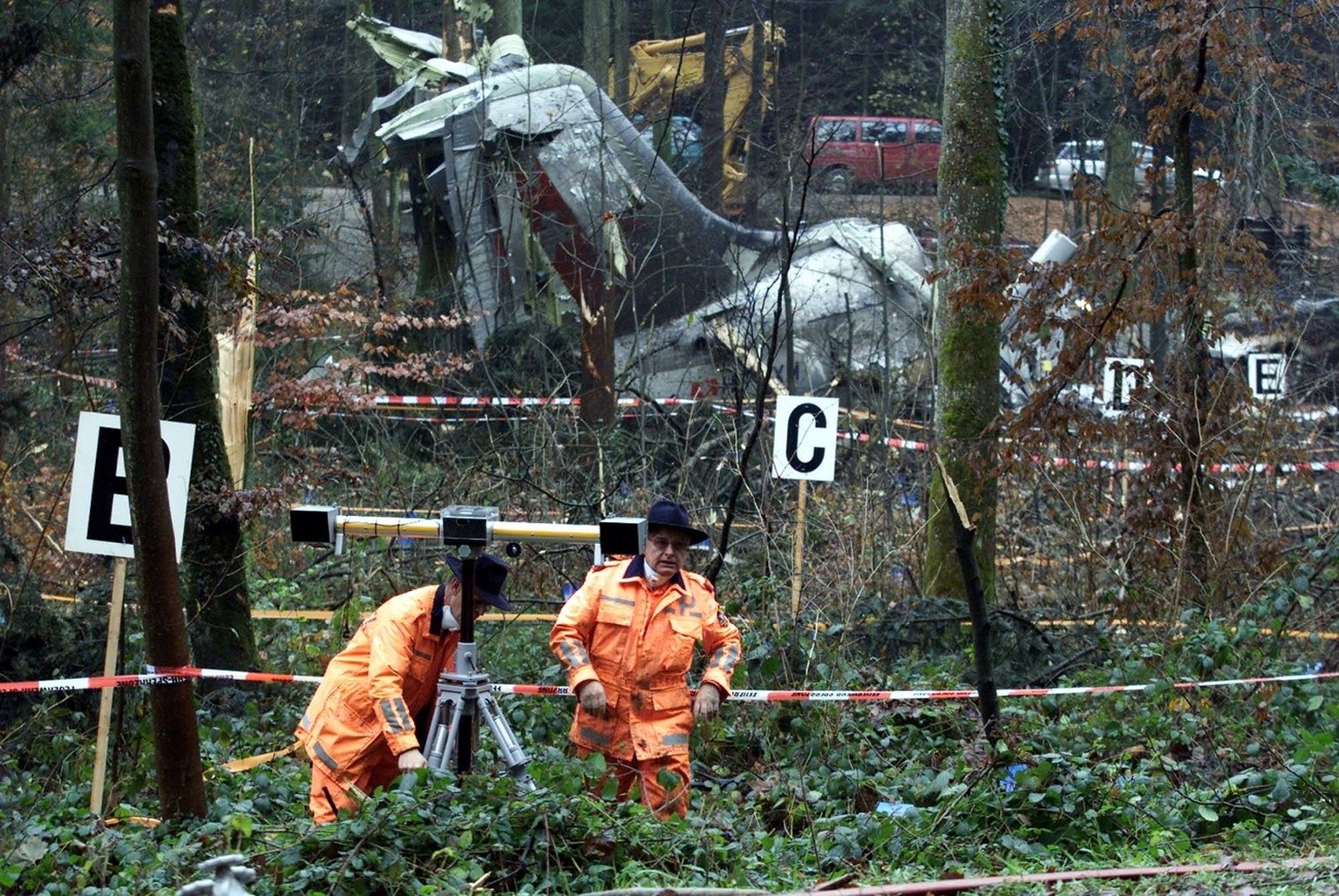Rescue worker takes photographs, on Monday, Nov. 26, 2001, in front of the crashed Crossair jet in a forest near Bassersdorf, Switzerland, Monday Nov. 26, 2001. The Jumbolino LX 3597 of the Swiss airl ...