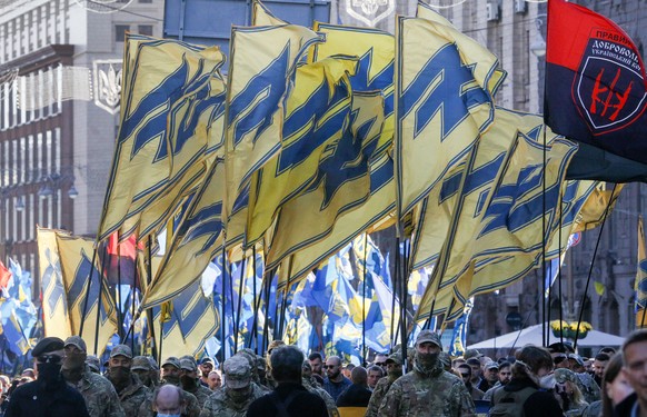 Soldiers of Ukrainian right-wing paramilitary Azov National Corps with their flags attend a rally marking Defender of Ukraine Day in centre Kyiv, Ukraine, Wednesday, Oct. 14, 2020. (AP Photo/Efrem Luk ...