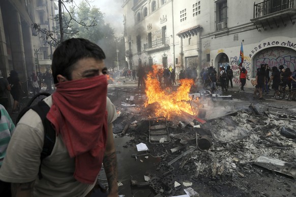 Anti-government demonstrators burn garbage and furniture in a barricade during a march in Santiago, Chile, Tuesday, Oct. 22, 2019. Protests in the country have spilled over into a fifth day, even afte ...