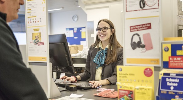 Da lacht der Kunde und die Postangestellte strahlt: Die Post belässt die Preise für A- und B-Post.