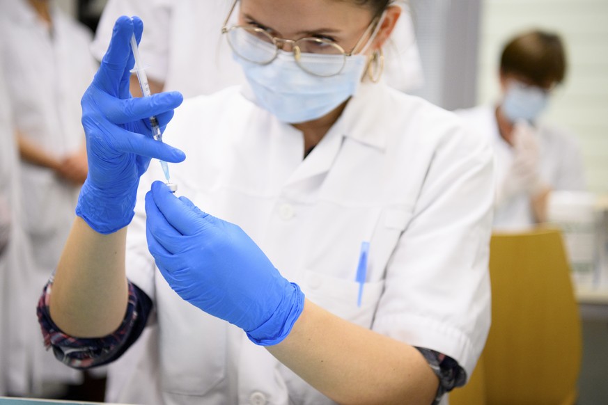 Health worker prepares the Pfizer-BioNTech COVID-19 for vaccination during the vaccinations against the coronavirus disease (COVID-19) on the opening day of the vaccination centers in the canton of Va ...