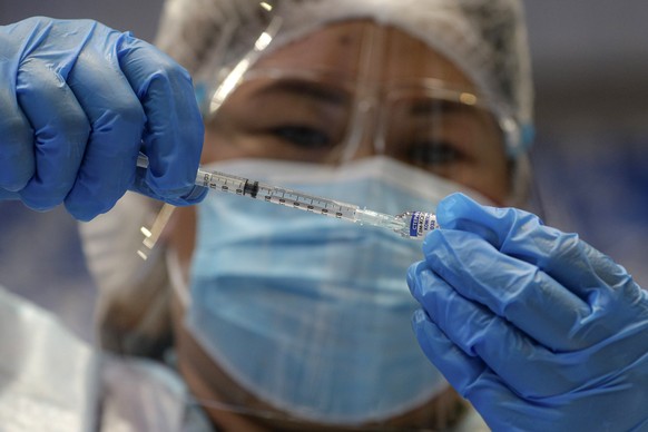 FILE - A health worker prepares to administer Russia&#039;s Sputnik V COVID-19 vaccine inside the Makati Coliseum, in Manila, Philippines on May 4, 2021. On Monday, the U.S. will implement a new air t ...