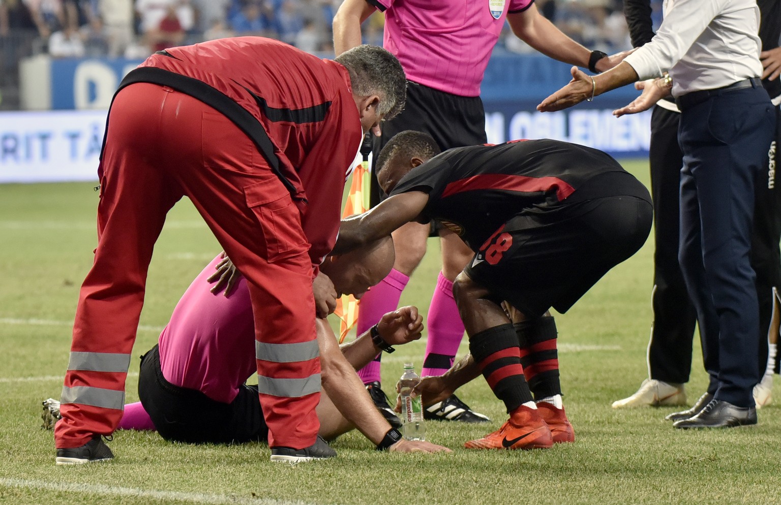 epa07752438 The main referee Arnold Hunter (cenetr, down), from Northern Ireland, receives medical care after a firecracker sent by supporters incapacitated him during the extra time of the UEFA Europ ...