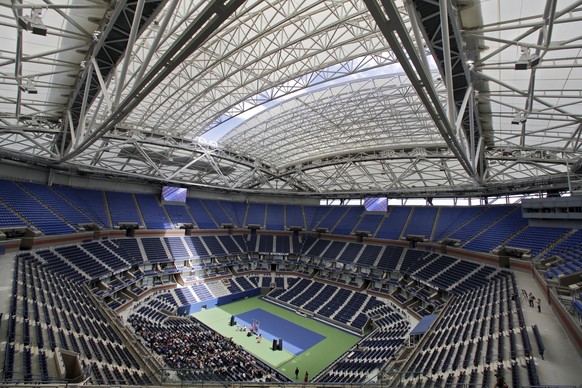 The partially open new retractable roof allows a ribbon of light into Arthur Ashe Stadium at the Billie Jean King National Tennis Center, in the Queens borough of New York, Tuesday, Aug. 2, 2016. Moth ...