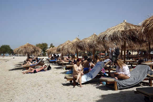 epa09186816 People enjoy a sunny day at the beach at a resort near Athens, Greece, 08 May 2021 (issued 09 May 2021). Equipped beaches charging entrance fees reopened on 08 May based on safety protocol ...