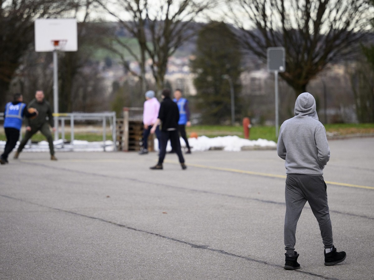 Un refugie marche dans la court alors que des employes de ORS (Organisation for Refugee Services) jouent au basket dans la court de la caserne lors d'une visite de presse, organisee par le Secret ...
