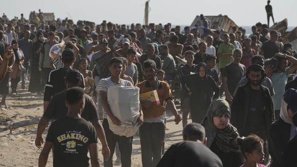 Palestinians carry boxes containing food and humanitarian aid packages delivered by the Gaza Humanitarian Foundation, a U.S.-backed organization approved by Israel, in Rafah, southern Gaza Strip, on T ...