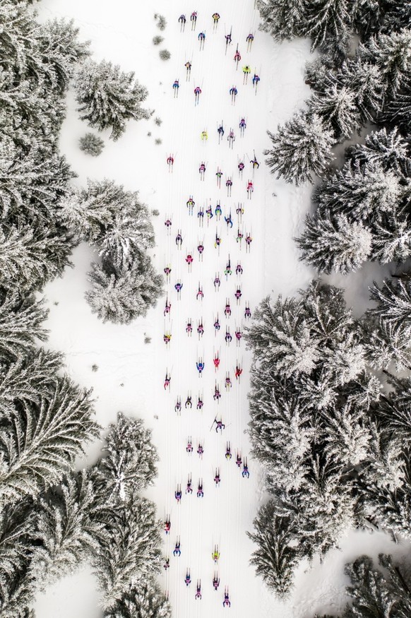 The photo taken in March 2022 shows the competitors of the annual ski event: Bieg Piastów held in Szklarska Poręba, at its 46th edition. Skiers whiz in their colorful clothing along the track surround ...