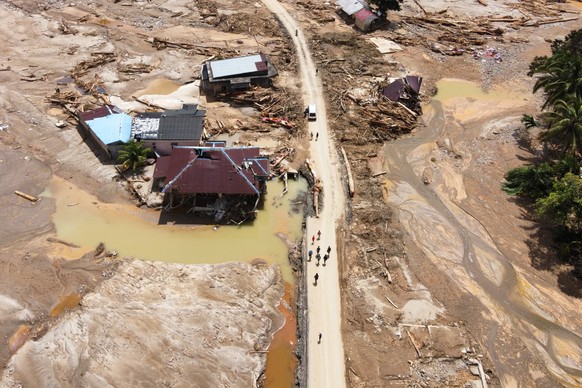 People walk along a road through a village affected by a flash flood in Batang Toru, North Sumatra, Indonesia, Monday, Dec. 1, 2025. (AP Photo/Binsar Bakkara)
Indonesia Extreme Weather