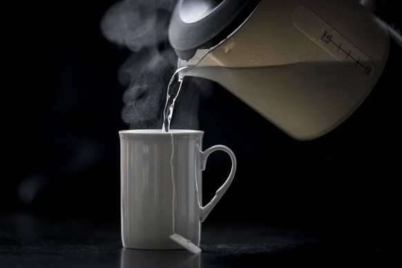 Heisses Wasser wird von einem Wasserkocher in eine Tasse mit einem Teebeutel gegossen. Berlin, 05.02.2019. Berlin Deutschland *** Hot water is poured from a kettle into a cup with a tea bag Berlin 05  ...