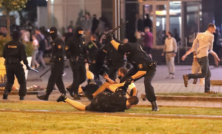 epa08594451 A riot police officer hits a demonstrator during a protest after polling stations closed in the presidential elections, in Minsk, Belarus, 09 August 2020. Five candidates are contesting fo ...