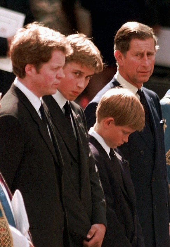 Prince William (second from left) watches the hearse pull away from Westminster Abbey carrying the body of his mother Princess Diana as his father the Prince of Wales looks on after a funeral service  ...