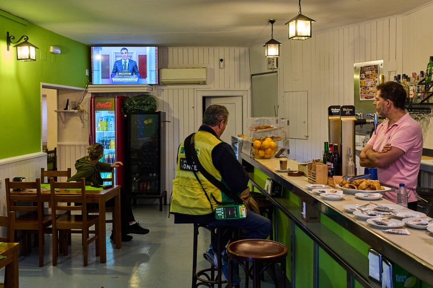 People at a bar in La Cabrera, on the outskirts of Madrid, Spain, watch a televised speech by Spanish Prime Minister Pedro Sanchez from La Moncloa Palace announcing national elections, Monday, Oct. 5, ...