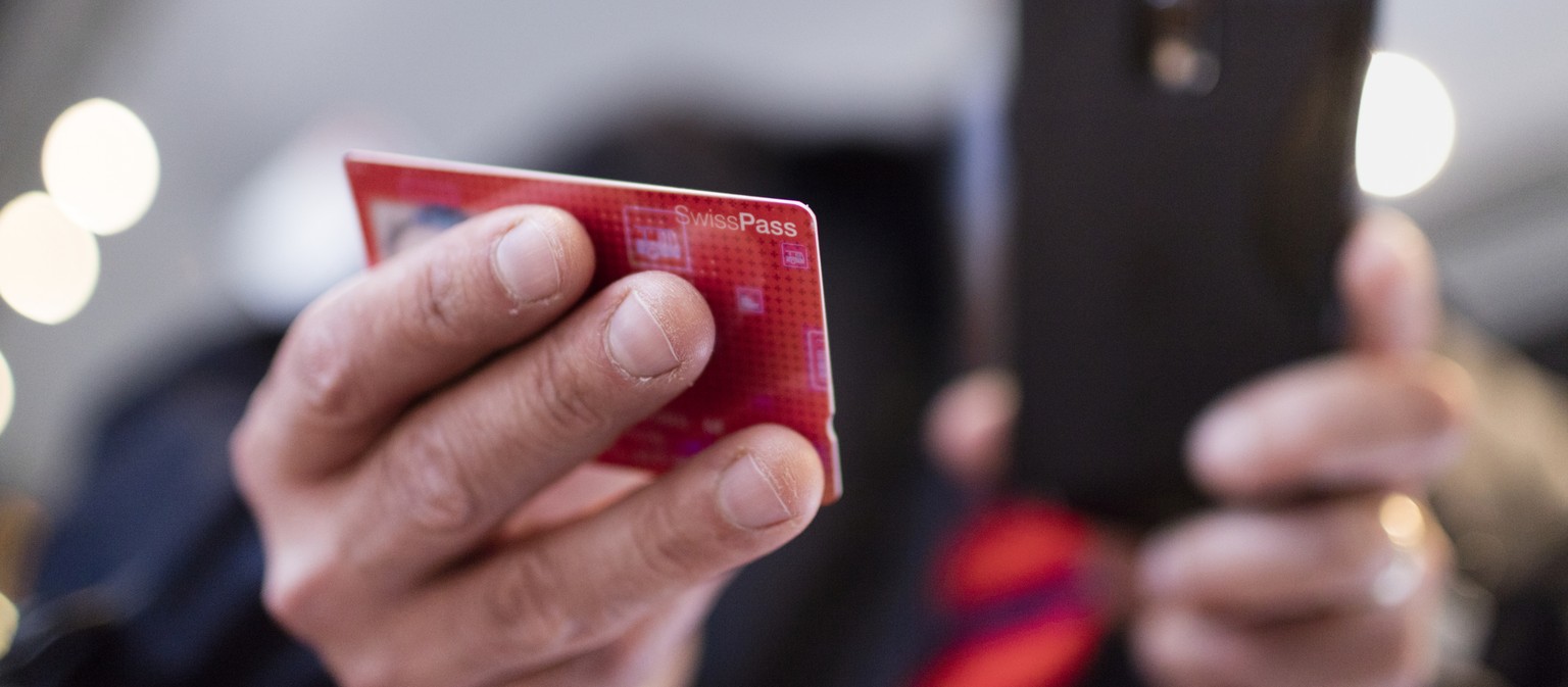 ZUR EINFUEHRUNG DES SWISSPASSES VOR DREI MONATEN STELLEN WIR IHNEN HEUTE, MITTWOCH, 4. NOVEMBER 2015, FOLGENDES NEUES BILDMATERIAL ZUR VERFUEGUNG --- A conductor verifies a train passenger&#039;s Swis ...