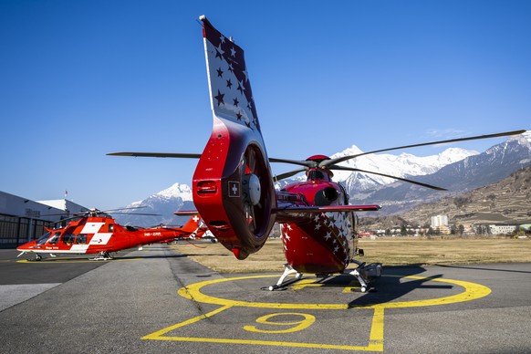 Un helicoptere de la compagnie Air Glaciers attend sur la base avant de partir pour un sauvetage en montagne, a cote d&#039;un helicoptere de La Rega, la Garde aerienne suisse de sauvetage, qui attend ...