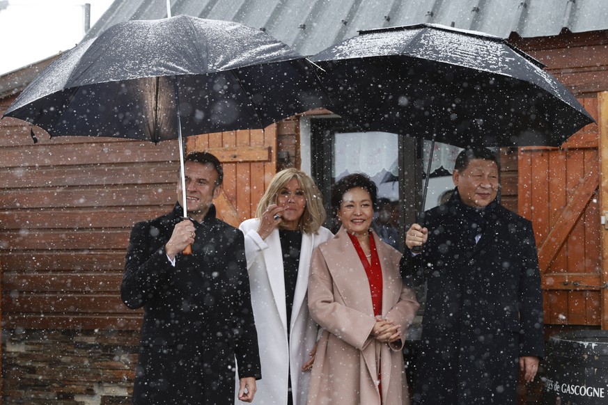 epa11324622 (L-R) French President Emmanuel Macron and his wife Brigitte Macron, Chinese President&#039;s wife Peng Liyuan and Chinese President Xi Jinping watch folklore dancers at the Tourmalet Pass ...