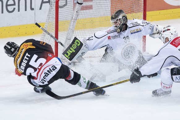 Berns Andrew Ebbett, links, im Duell mit Luganos Torhueter Sandro Zurkirchen, Mitte, und Alessio Bertaggia im Eishockey Meisterschaftsspiel der National League zwischen dem SC Bern und dem HC Lugano,  ...