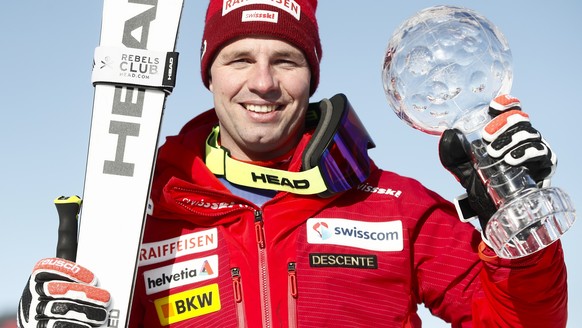 Switzerland's Beat Feuz poses with the alpine ski, men's World Cup downhill trophy, in Kvitfjell, Norway, Saturday, March 7, 2020. (AP Photo/Gabriele Facciotti)