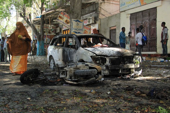 epa11082444 People inspect the scene after a suicide bombing blast near a restaurant in Hamar Weyne district in Mogadishu, Somalia, 16 January 2024. Somali police forces confirmed that three people we ...