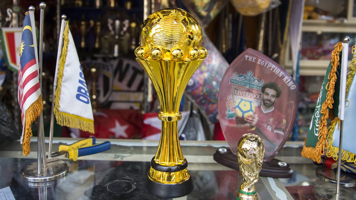 epa07647762 African cup of nation statue displayed with a photo of Mohamed Salah the Egyptian footballer for sale at a shop as preparation for the African cup in downtown Cairo, Egypt, 14 June 2019. E ...