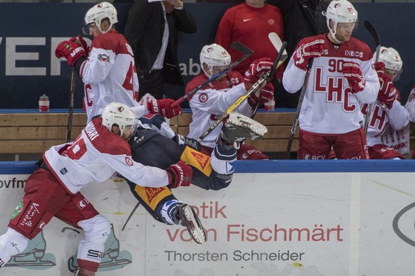 Matteo Nodari, links, von Lausanne im Spiel gegen einen Zuger, rechts, beim Eishockey Meisterschaftsspiel in der Qualifikation der National League zwischen dem EV Zug und dem HC Lausanne vom Dienstag, ...