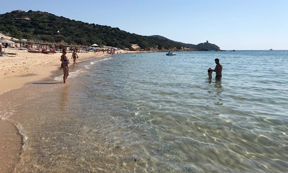 FILE - In this June 29, 2019 photo, people enjoy the white sand and pristine waters of Chia beach, on the Italian island of Sardinia, Italy. Italian media on Saturday, June 5, 2021 said customs police ...