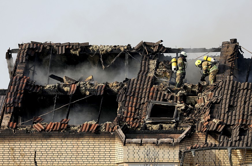07.08.2018: Nordrhein-Westfalen, Siegburg: Feuerwehrleute stehen in einem ausgebrannten Dachstuhl eines Wohnhauses. Nach einem Boeschungsbrand direkt an der wichtigen Bahnstrecke Koeln-Frankfurt hatte ...